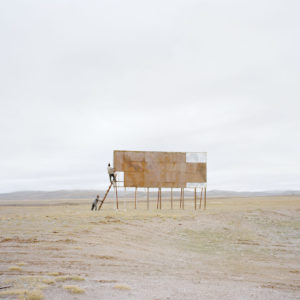 Zhang Kechun, The Yellow River No.09 – Men climbing a billboard, Qinghai, 2010, Inkjet print, 115 x 147 cm