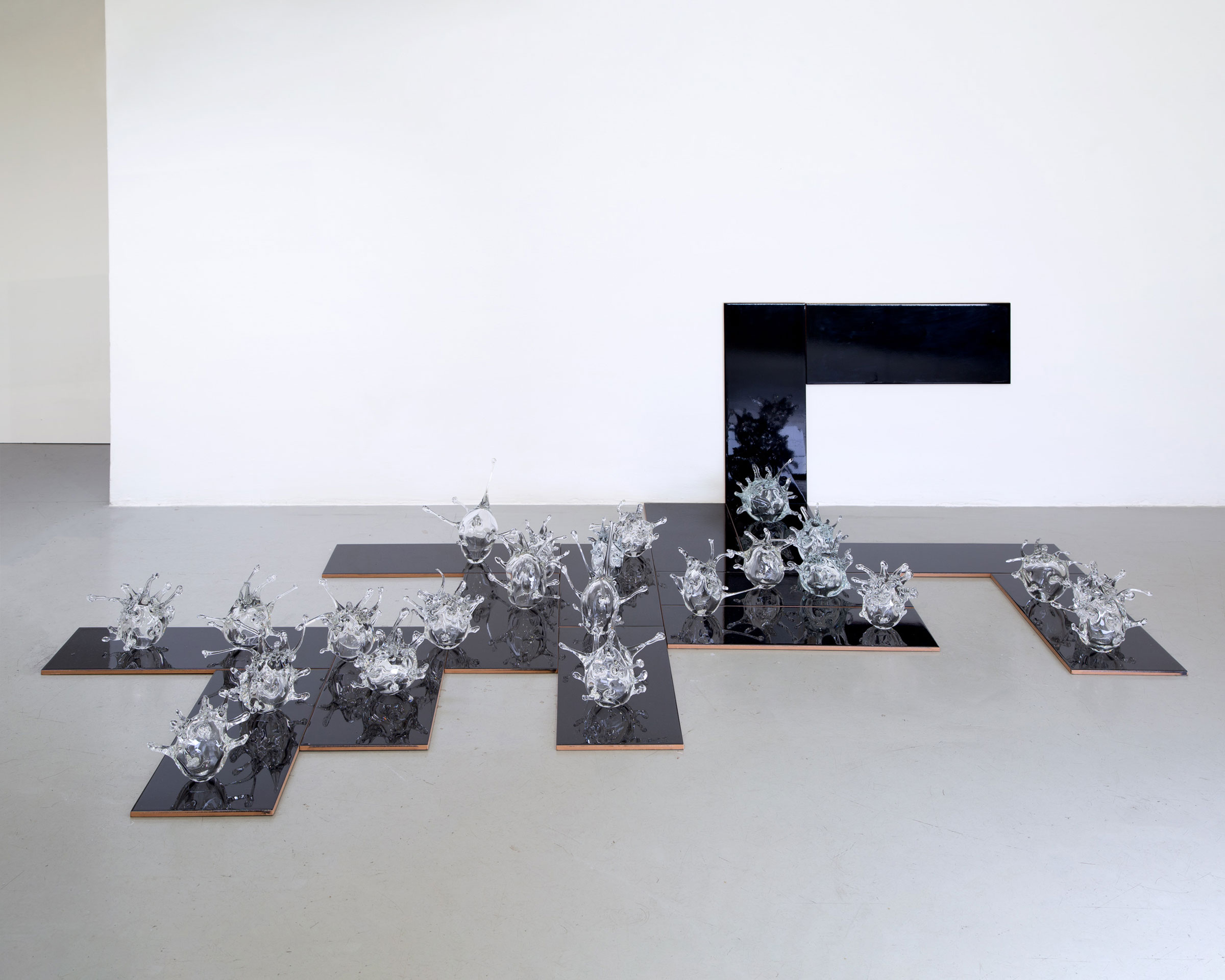 Ádám Albert, Disconnected, 2020, 21 pieces blown glass (variable size), black tile (per piece, 50 x 20 cm)